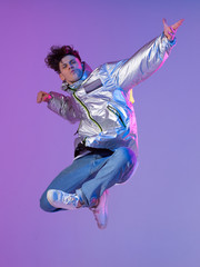 Cool guy dancing contemporary dance in studio. Neon light background. Acrobatic bboy dancer. Break...