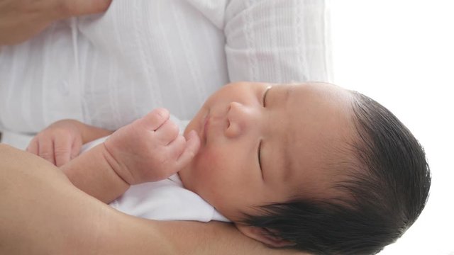 Little asian baby sleeping on mother arms.