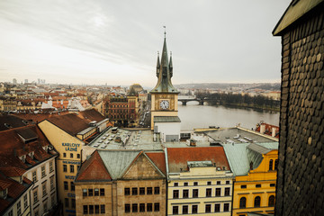 Naklejka premium Close up view to old Town Bridge Tower, clock tower and St. Francis Of Assisi Church in Prague, Czech Republic while sunset. 