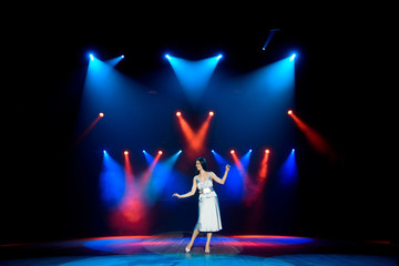 Artist posing on the scene in club. Bright stage lighting