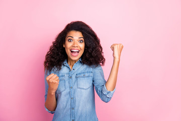 Portrait of amazed crazy afro american girl win hear wonderful lottery win news scream wow omg feel rejoice emotions raise fists wear casual style outfit isolated over pink color background