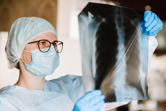 Doctor Specialist Pulmonary Medicine Holding Radiological, Chest X-ray Film For Medical Diagnosis On Patient Health On Infected Coronavirus, Covid-19, Asthma, Lung Disease And Bone Cancer Illness.