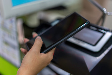 Contactless payment. Customer woman using Mobile phone scanning for payment. Woman paying with mobile phone in cafe shop. Mobile payments online shopping. Selective focus.