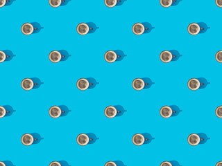 top view of cups of fresh coffee on blue, seamless background pattern
