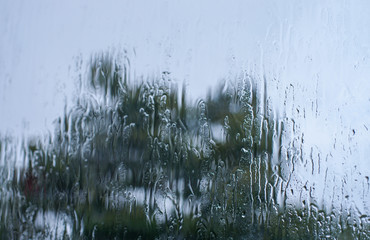 Rain drops on window glasses surface with bokeh background.