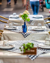 A row of chairs and tables at a outdoor cafe on Lygon Street, Carlton, Melbourne, Australia
