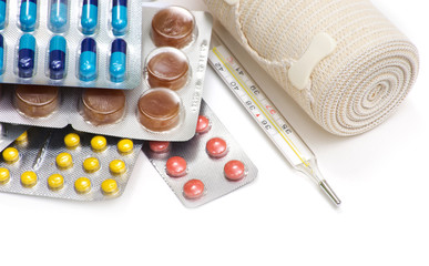 Pills, the thermometer with medicines on a white background