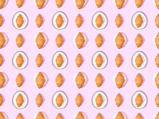 top view of croissants on plates on pink, seamless background pattern