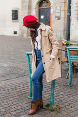 Beautiful young woman at city street. Happy tourist girl walking outdoors. Spring full body fashion portrait of pretty brunette female posing in old town.
