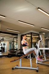 Fototapeta na wymiar Young woman have a training at sit up bench in the gym