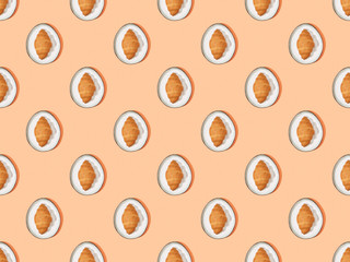 top view of fresh croissants on plates on orange, seamless background pattern