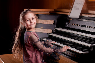 Little girl playing a pipe organ