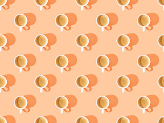 Fototapeta na wymiar top view of cups of fresh coffee on orange, seamless background pattern