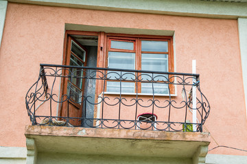 window and open door to the balcony of the old house. Balcony with metal railings.