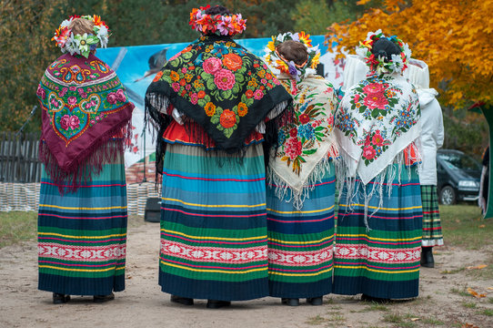 Women in Belarusian folk costumes. Embroidered dresses and painted scarves. Traditional autumn harvest festival. People and traditions.