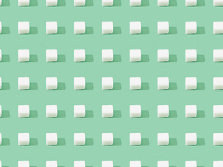 top view of lump sugar on green, seamless background pattern