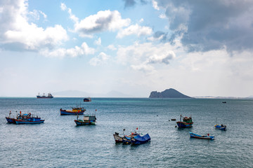 Fishing boats and freight ships in a bay in Vietnam