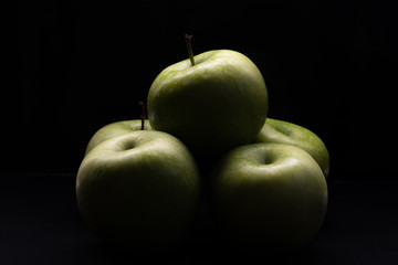 Green apples on a black background