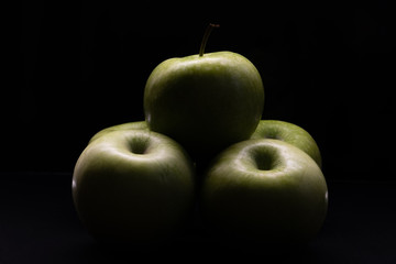 Green apples on a black background