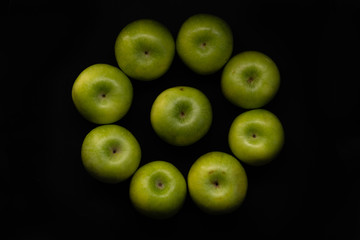 Green apples on a black background