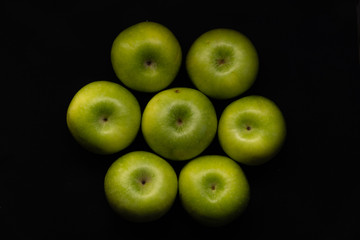 Green apples on a black background