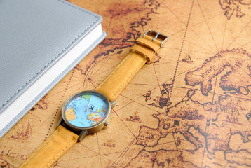travel watch and notebook on world map