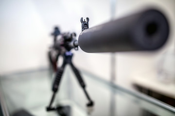 Sound suppressor or sound moderator and Iron sights on the gun barrel of semi-automatic rifled carbine, standing on stand. Iron sight in shallow DoF(depth of field).