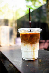 A close up view of iced caramel macchiato on a rusty table