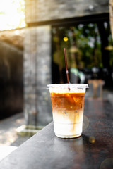 A close up view of iced caramel macchiato on a rusty table