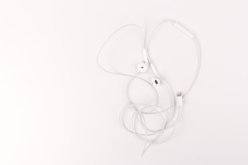 White headphones for listening to music and sound on portable devices: music player, smartphone, laptop and jack for connection on a white background.