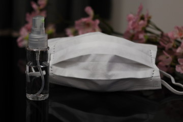 白いマスクと桜とアルコール消毒スプレー