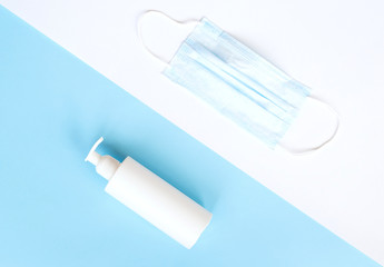 medical mask, disinfector, soap, pills on a blue background. flat lay