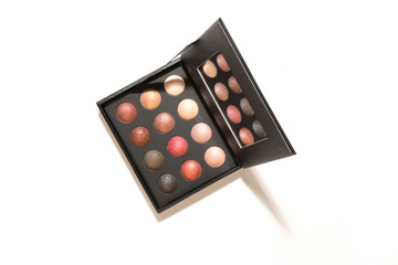 Eyes makeup palette. Sculpting blush, highlighter, bronzer cosmetic products. Black square plastic container with twelve round color samples for luminous look