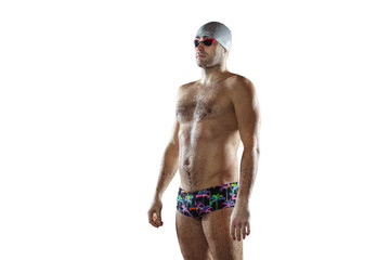 Professional caucasian male swimmer with hat and goggles practicing and training isolated on white studio background. Grace of motion and action. Healthy lifestyle, sport and movement concept.