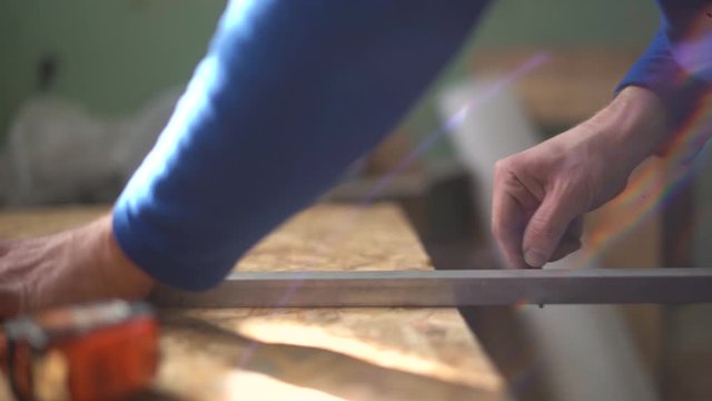 Hands Of Man Using A Ruler To Make Measurements On A Piece Of Wood. Holding a pencil. Slowmotion