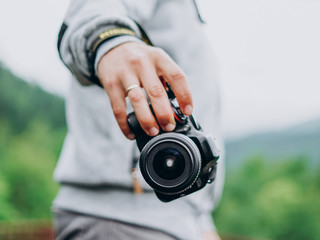 Male hand holding a camera. Photographer man