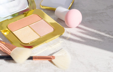 premium makeup brushes, sponge and blush pads on a light marble background, creative cosmetics flat lay