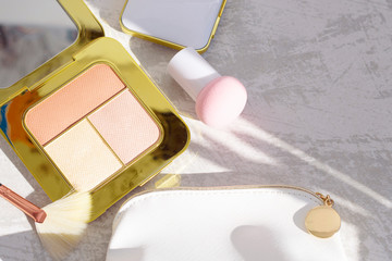 premium makeup brushes, sponge and blush pads on a light marble background, creative cosmetics flat lay