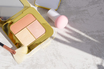 premium makeup brushes, sponge and blush pads on a light marble background, creative cosmetics flat lay