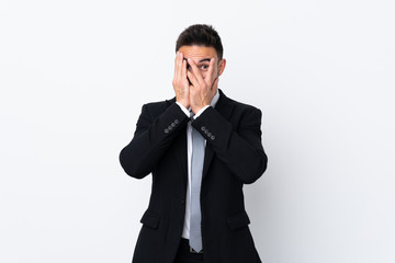 Young business man over isolated background covering eyes and looking through fingers