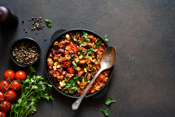 Chili con carne classic mexican dish on the kitchen table, top view.