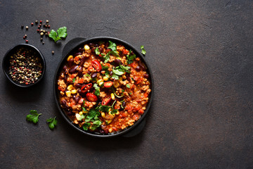 Chili con carne classic mexican dish on the kitchen table, top view.