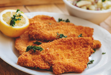 original Wiener Schnitzel, goldgelb gebacken, frisch und knusprig mit Zitrone und frittierter Petersilie dekoriert. Nationalspeise aus Österreich