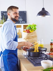 Smiling and confident chef standing in large kitchen