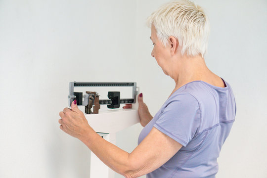 Active Senior Woman Checking Her Weight On The Scales