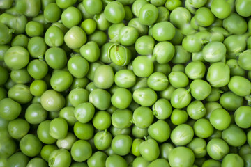 Green pea closeup macro. Horizontal photo of peeled peas on the market bench / counter / stand. Vegetable of summer season. 