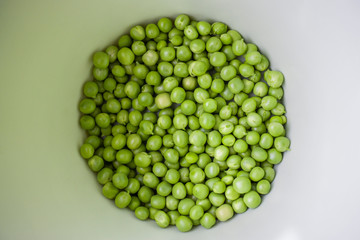 Green pea closeup in a bowl. Horizontal photo of peeled peas on the market bench / counter / stand. Vegetable of summer season. 