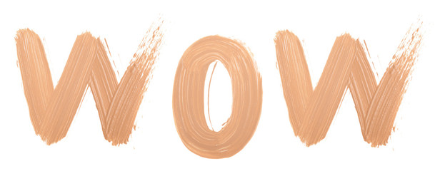 WOW word text made with face skin concealer nude color.  Brush stroke make up base creamy texture isolated on white background.