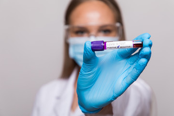 Nurse holding test tube with Positive Coronavirus test blood sample. 2019-nCoV pandemic....