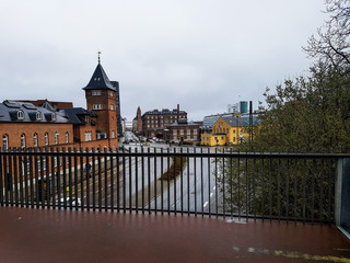 A bridge over a street in Copenhagen with a tower in the background